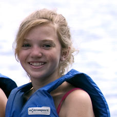 A young girl in a boat smiles