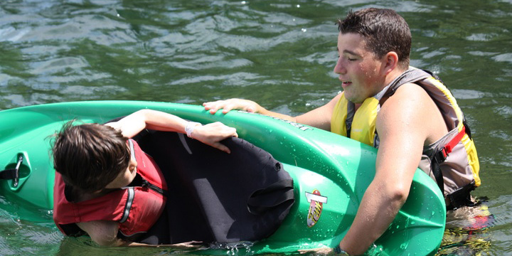A Counselor Helping a Camper Kayak at Coed Camp